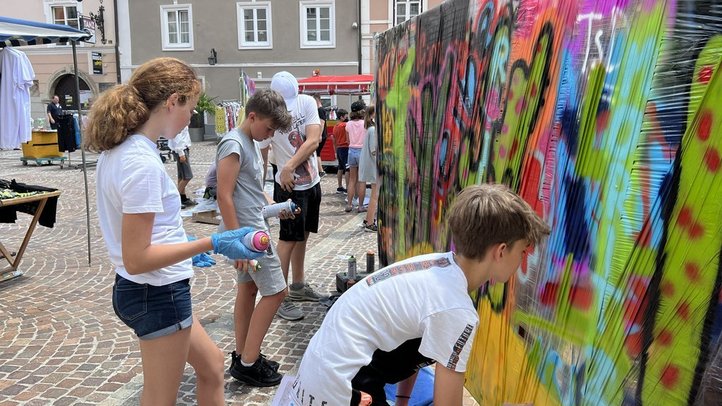 Jugendliche besprayen eine Wand mit Graffiti